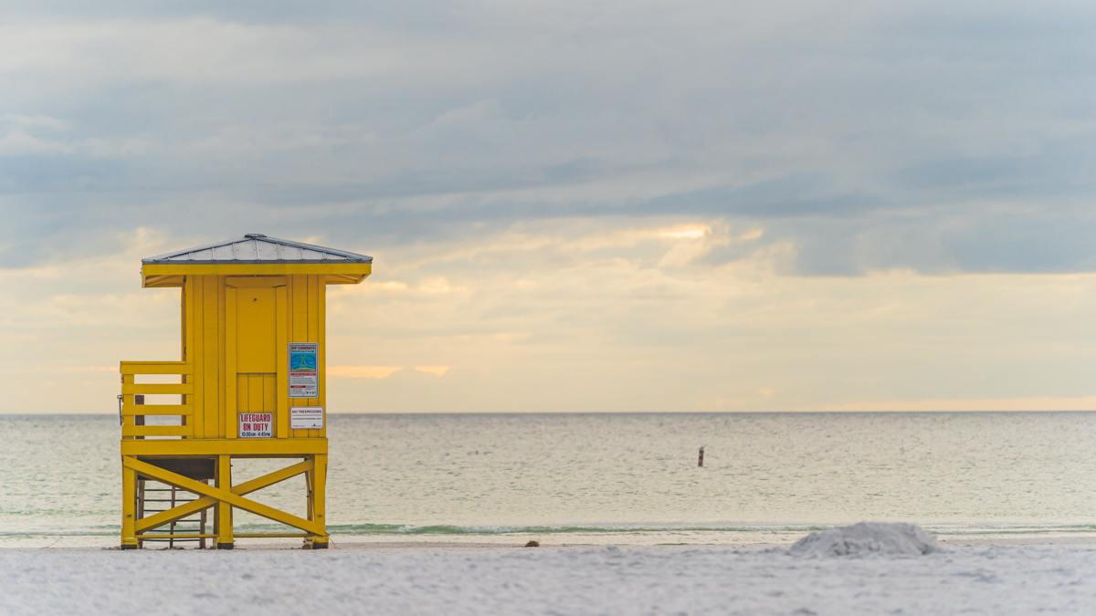 yellow lifeguard hut on sandy siesta KEy beach at sunset. © Joel Hartz