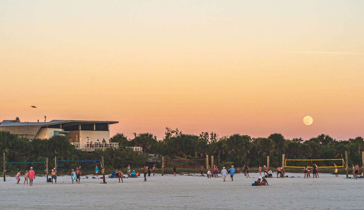 The moon rises above the volleyball nets on Siesta Key Beach, Florida at sunset © Joel Hartz