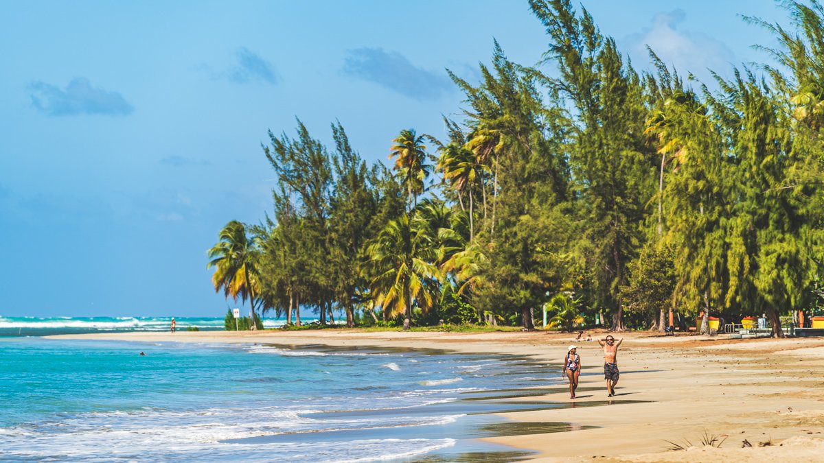 Couple walk along Luquillo Beach, Puerto Rico