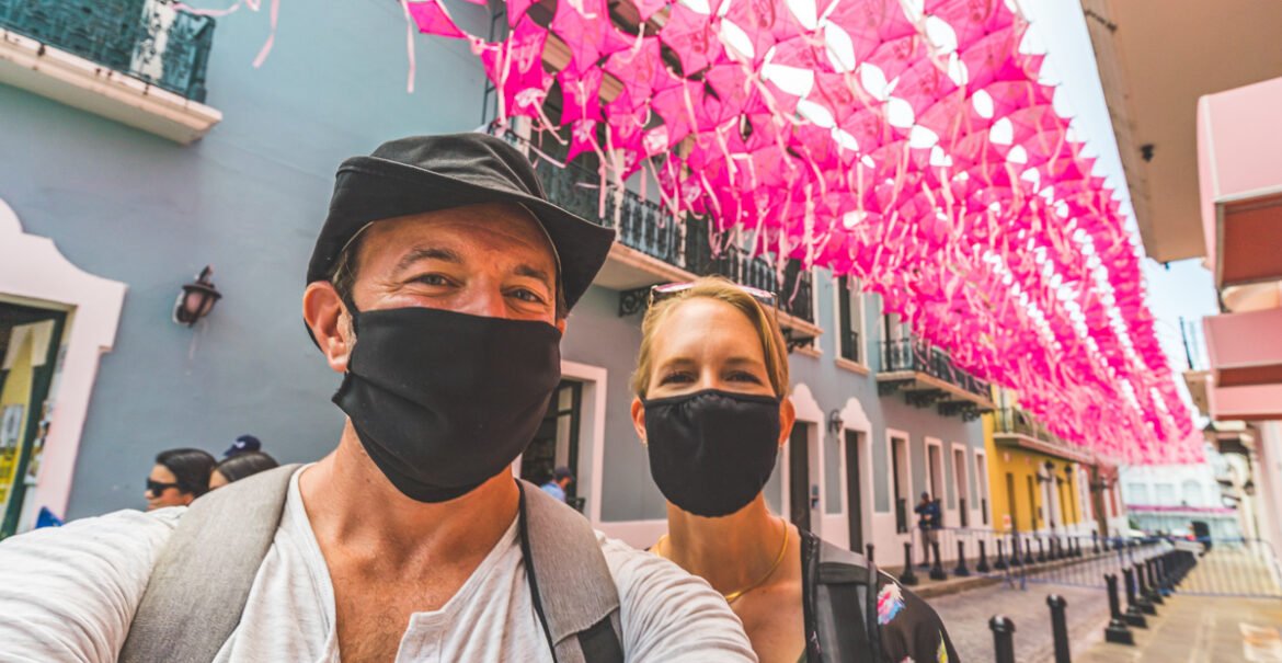 Wanderinghartz selfie in front of pink kites over Calle Fortaleza in Old San Juan Puerto Rico