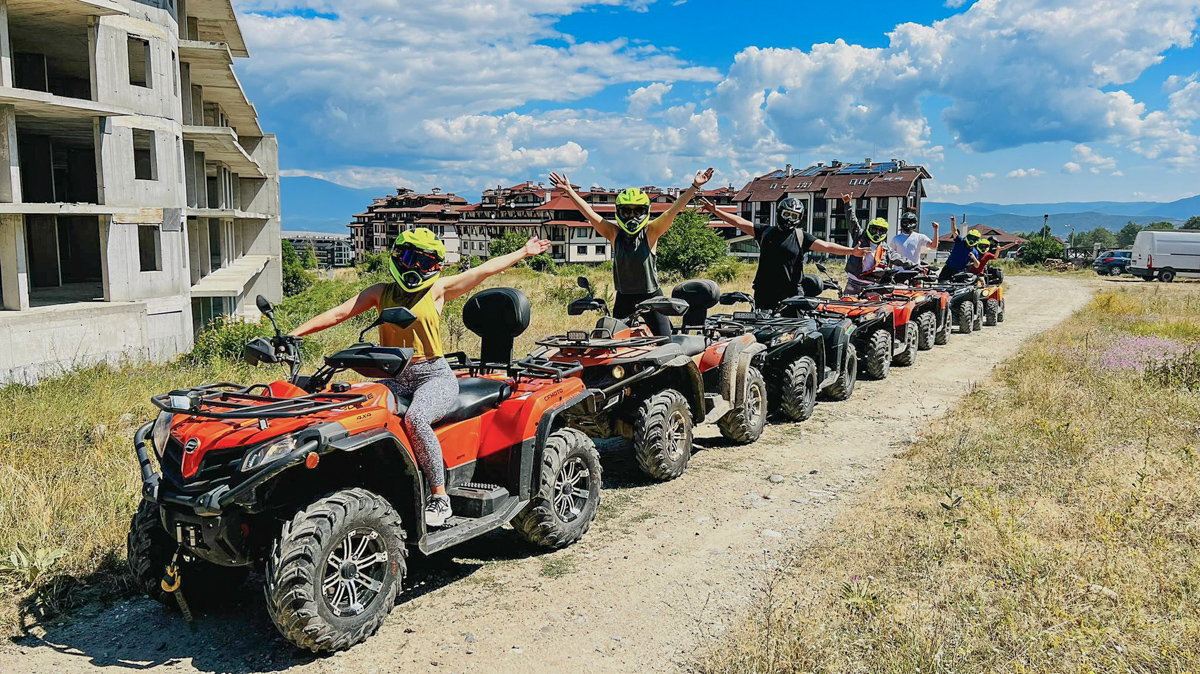 A line of riders in helmets sitting on ATV's in Bansko