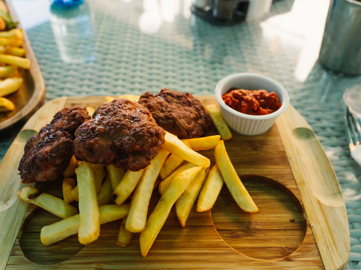 bulgarian Meatballs with fries served on wooden plate