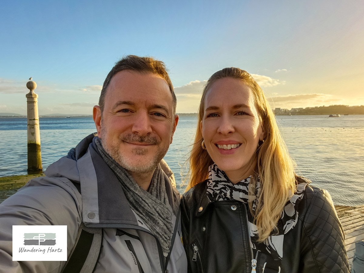 travel bloggers Joel and Michelle hartz taking a selfie in lisbon portugal at sunset