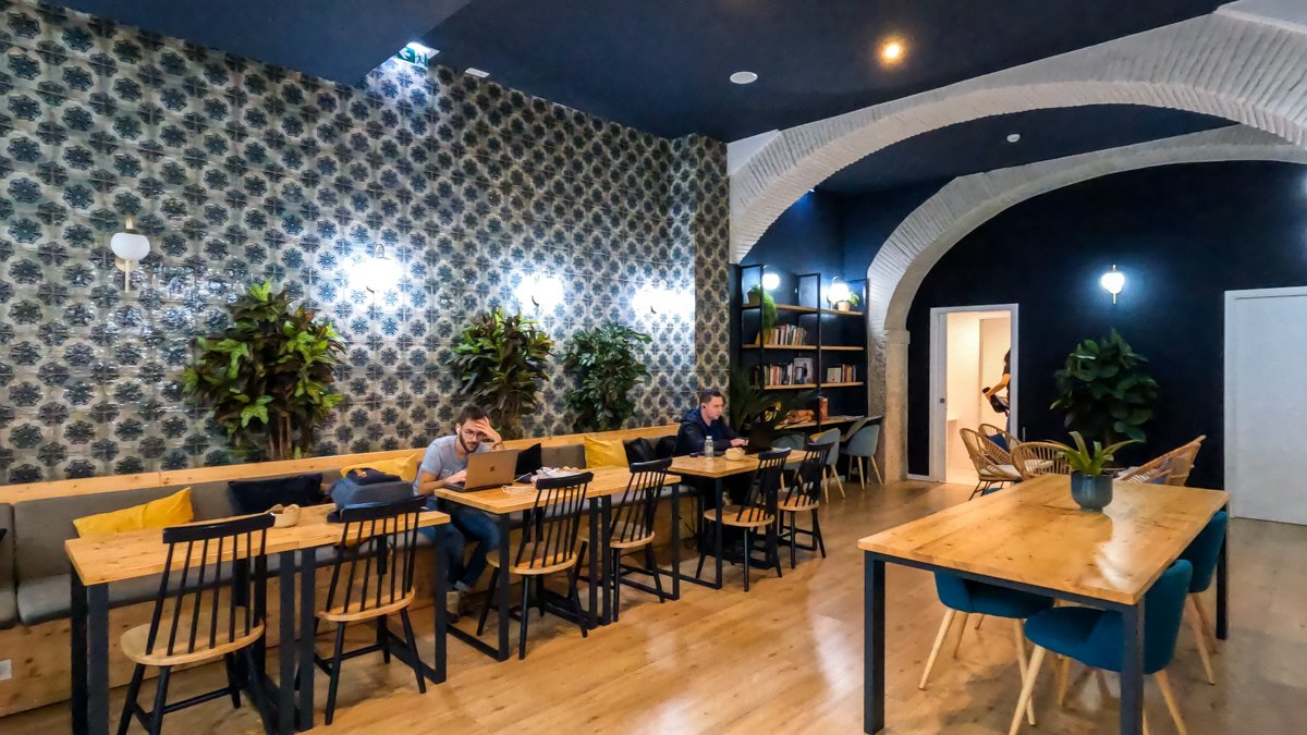 One of two lounges in the Central House Hostel Baixa Lisbon. tables and chairs with people working © Joel Hartz