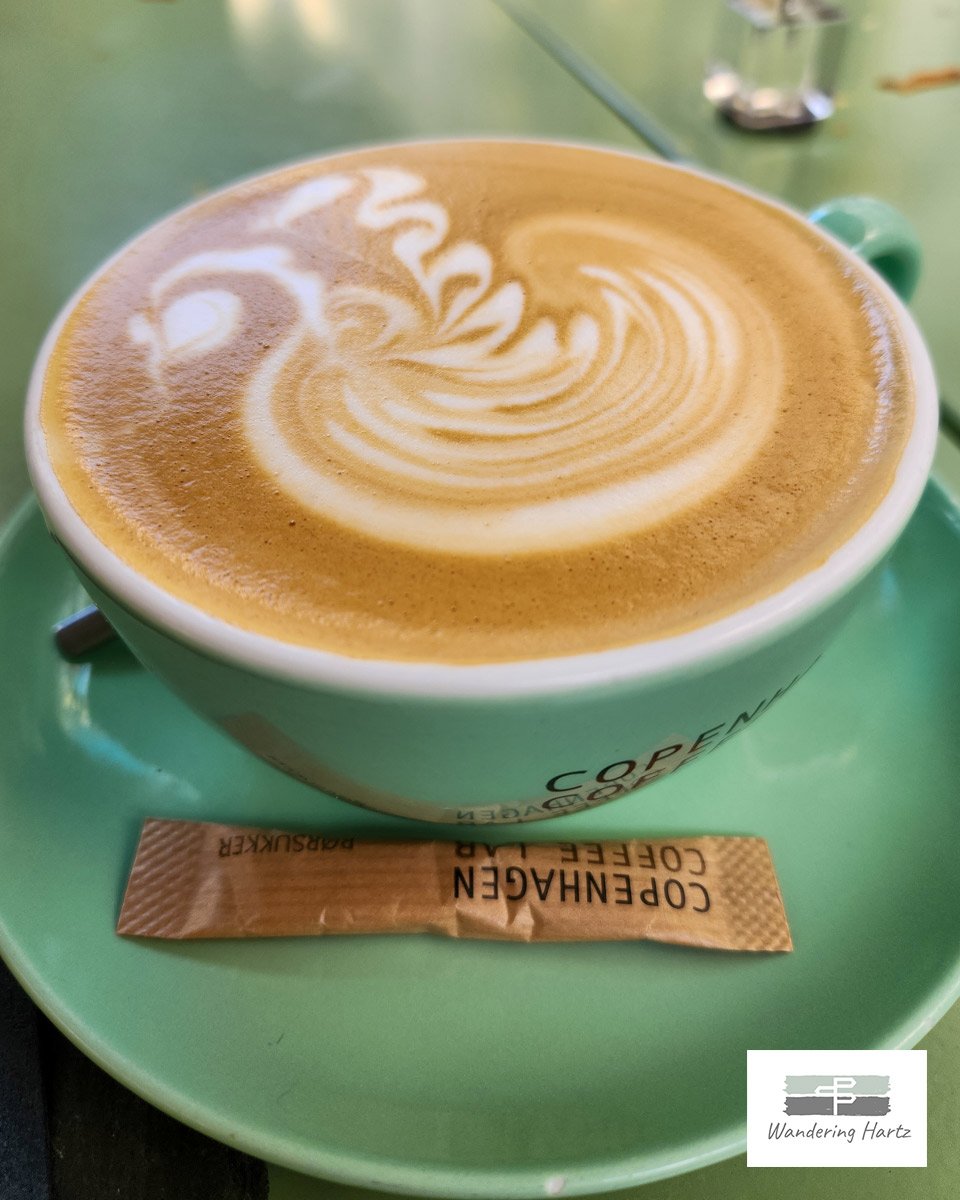 close shot of cup of cappuccino in mint green cup and saucer