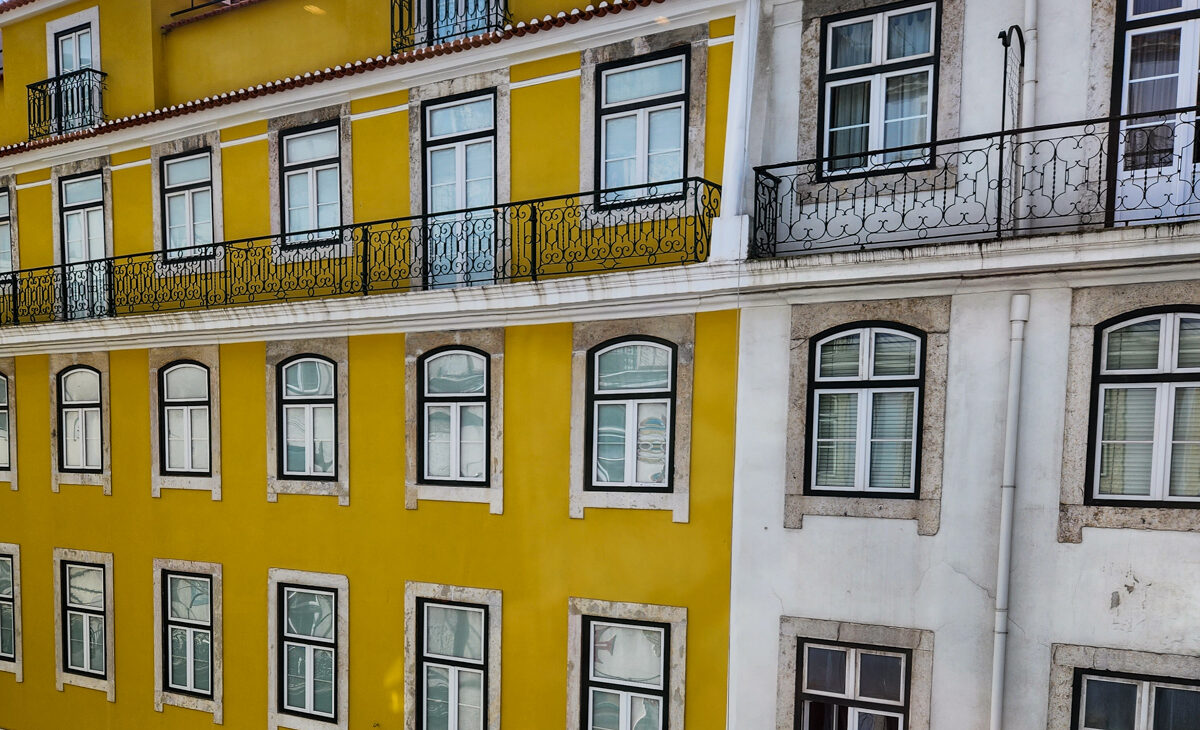 view from room of yellow and white building facades in Lisbon portugal in Baixa neighborhood. © Joel Hartz