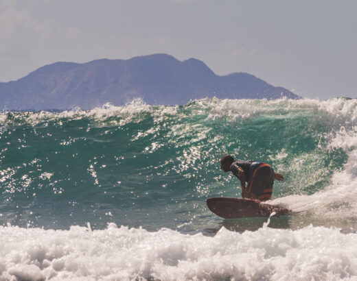 close up of surfer with Desecho Island, Puerto Rico in background © Joel Hartz