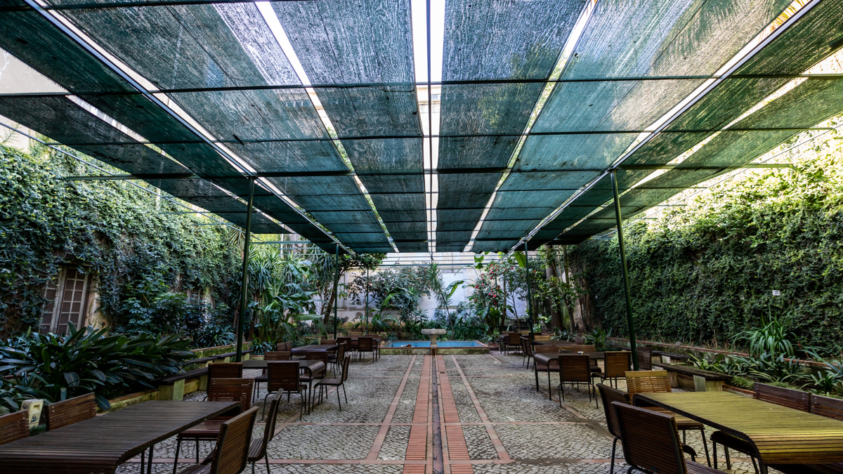 A view of garden like outdoor courtyard with shade canopy at the National Tile Museum cafe in Lisbon Portugal