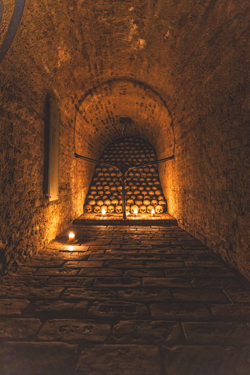 View of skulls stacked up with candles in the Ossuary at the Church of St James (Kostnice u sv. Jakuba)