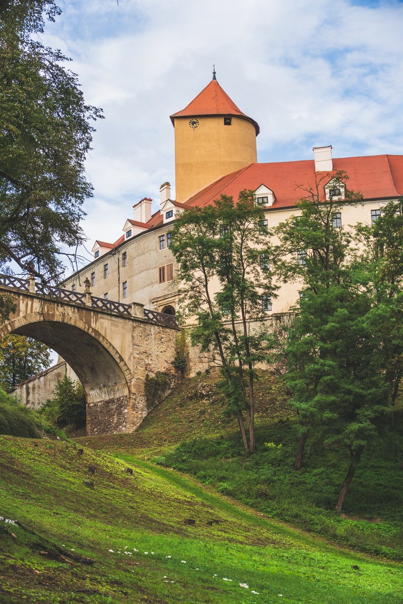 vertical image of the Veveří Castle from the walking path on partly cloudy day