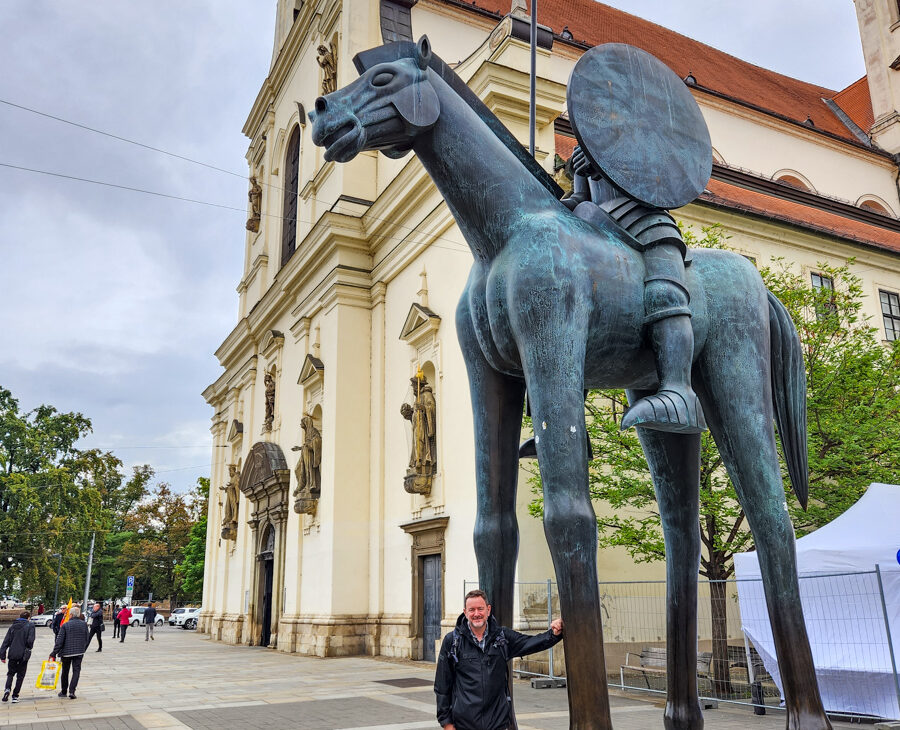 Joel Hartz posing with the Equestrian Statue of Margrave Jobst of Luxembourg in Brno, Czech Public