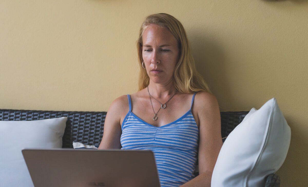 blonde woman working on laptop on patio in Puerto Rico