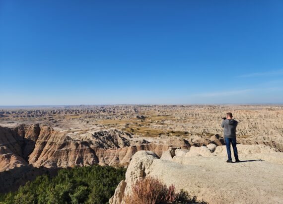 man standing on edge of overlook of Badlands South Dakota