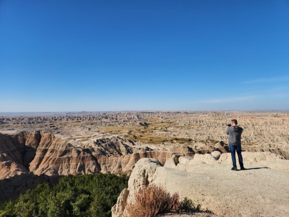 man standing on edge of overlook of Badlands South Dakota