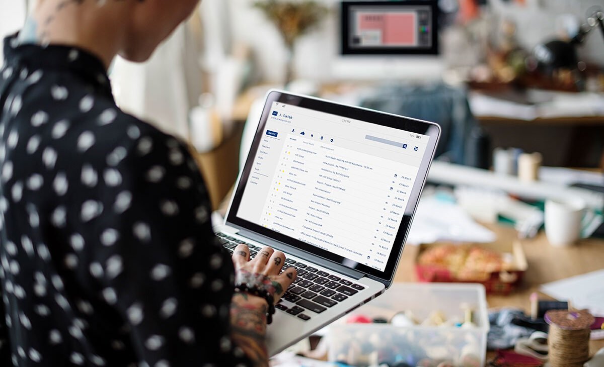 a woman holding a laptop and checking her e-mail