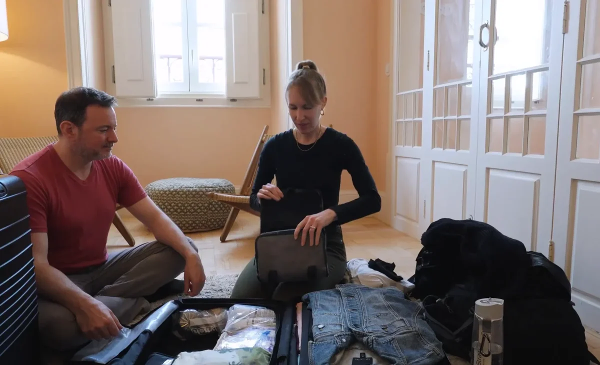 woman and man packing a suitcase in an apartment while slow travel living abroad