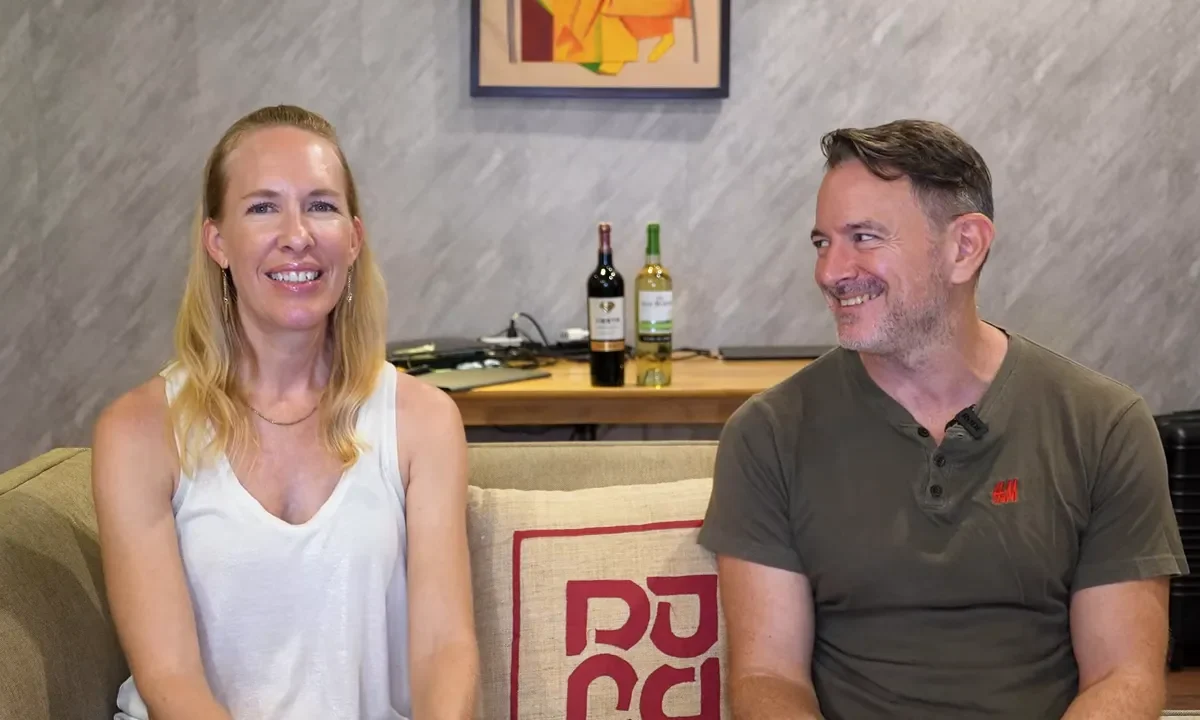 two people sitting on a couch smiling